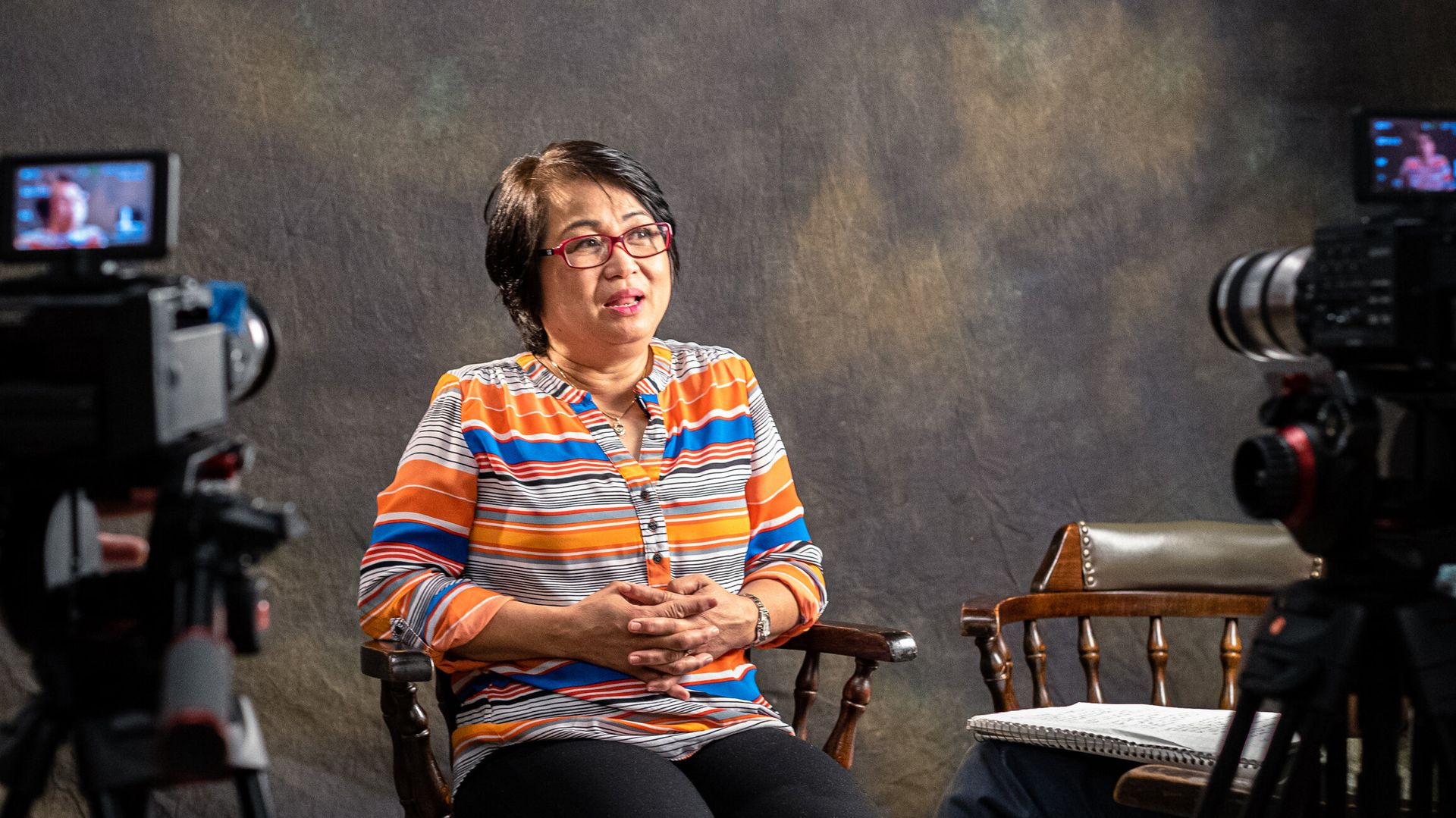 A woman being interviewed with cameras pointed at her