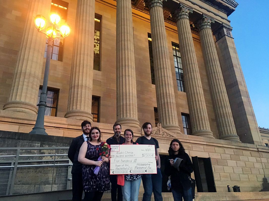 The Night Kitchen team holding a $500 People's Choice Award in front of the museum